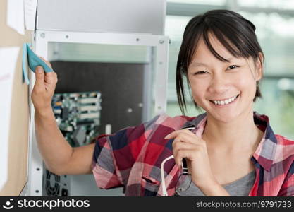 positive woman sticking sticky notes on a wall chart