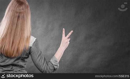Positiveness and success concept. Back view of blonde woman with long straight hair. Girl showing thumb up gesture. Body expression.. Back view of blonde woman with thumb up.