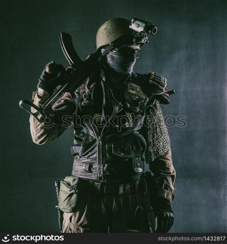 Post apocalyptic world bandit or marauder, nuclear disaster survivor, veteran stalker in face mask and sunglasses, handicraft lamellar armor, armed with handmade pistol, isolated on black studio shoot. Post apocalyptic survivor with handmade pistol