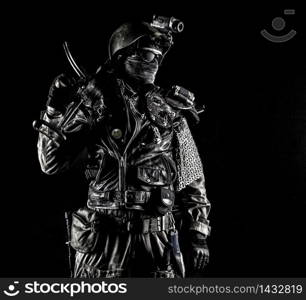 Post apocalyptic world bandit or marauder, nuclear disaster survivor, veteran stalker in face mask and sunglasses, handicraft lamellar armor, armed with handmade pistol, isolated on black studio shoot. Post apocalyptic survivor with handmade pistol