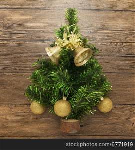 Postcard with a Christmas tree ,Christmas balls, bells, and star on wooden background.