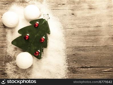 Postcard with a Christmas tree ,Christmas balls snowballs and snow on wooden background.