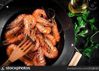 Pot of cooking shrimp with parsley. On a black background. High quality photo. Pot of cooking shrimp with parsley.