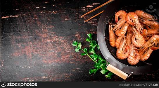 Pot of cooking shrimp with parsley. On a black background. High quality photo. Pot of cooking shrimp with parsley.
