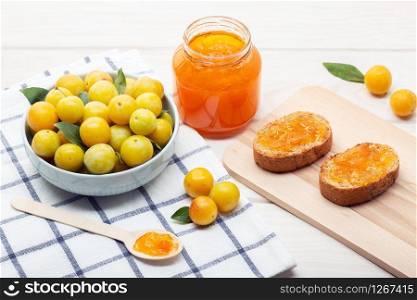 Pot of homemade sweet jam and toasts on wooden table. Delicious marmalade still life