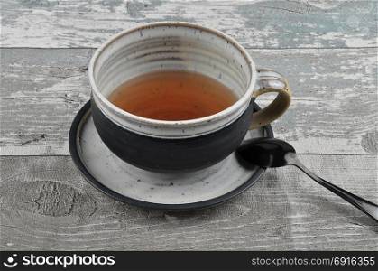 Pot with tea on vintage wood