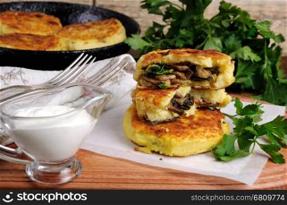 Potato cakes (zrazy) Stuffed mushrooms with herbs of the table with sour cream