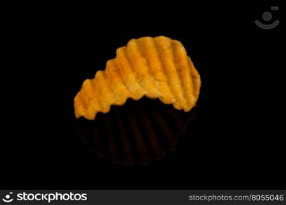 Potato chip on black surface closeup reflection detail
