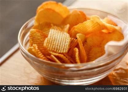Potato Chips In Bowl On Wooden Table At Sunset