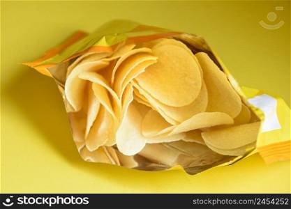 Potato chips on yellow background, Potato chips is snack in bag package wrapped in plastic ready to eat and fat food or junk food 