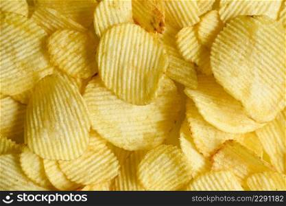 Potato chips texture background, Corrugated crispy potato chips snack - top view 