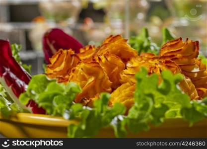 Potato croquettes on a yellow plate with salad