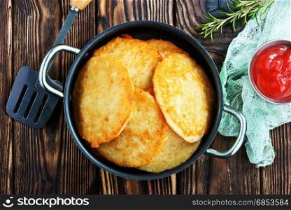 potato pancakes in pan and on a table