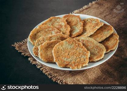 Potato pancakes on a plate on a linen background. Potato pancakes on a plate and fork on linen background