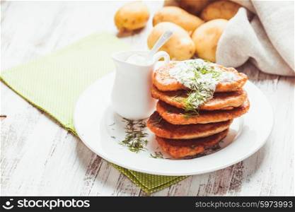 Potato pancakes with sour cream and dill. Potato pancakes
