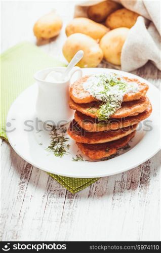 Potato pancakes with sour cream and dill. Potato pancakes