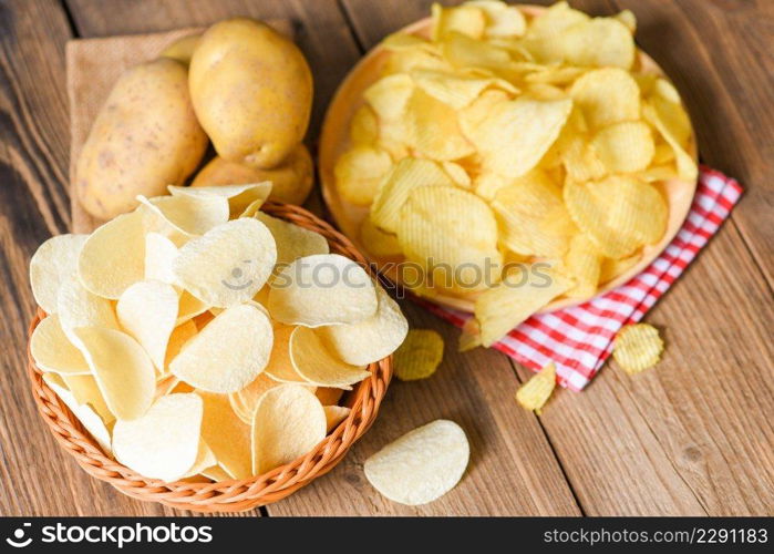 Potatoχps snack on plate top view, Crispy potatoχps in a basket on the kitchen tab≤and fresh raw potatoes