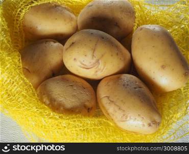 potato vegetables food. net sack of potatoes (Solanum tuberosum) vegetables vegetarian and vegan food