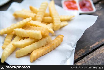 potatoes fries with sauce on a white paper