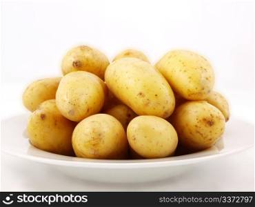 Potatoes on plate. Potatoes with shell on white plate towards white background