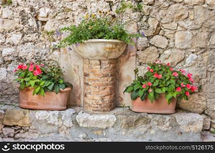 Pots of flowers near a old stone wall