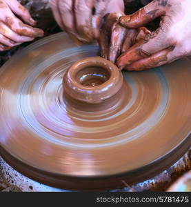 Potter&rsquo;s hands guiding child&rsquo;s hands to help him to work with the pottery wheel