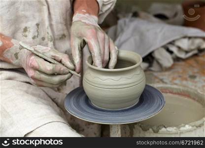 Potter&rsquo;s hands making a pot in a traditional style.