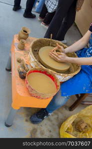 Potter`s hands shaping up the clay of the pot