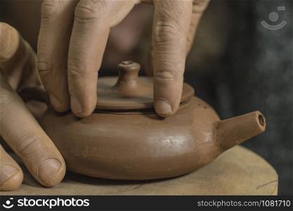 potter sculpts a chinese teapot from yixing purple clay