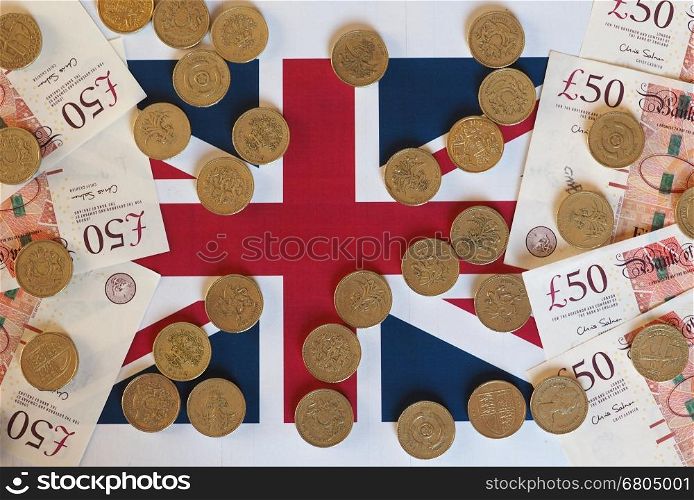 Pound coins and notes, United Kingdom over flag. Pound coins and banknotes money (GBP), currency of United Kingdom, over the Union Jack
