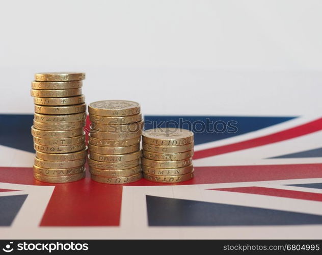 Pound coins, United Kingdom over flag. Pound coins money (GBP), currency of United Kingdom, over the Union Jack