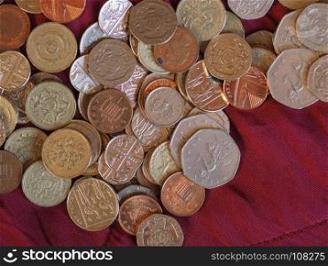 Pound coins, United Kingdom over red velvet background. Pound coins money (GBP), currency of United Kingdom over crimson red velvet background