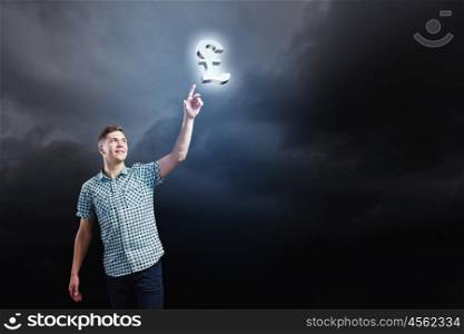 Pound currency concept. Young man and pound sign against dark background