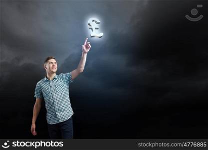 Pound currency concept. Young man and pound sign against dark background