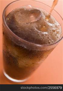Pouring a Cola into a Glass with Ice Cubes