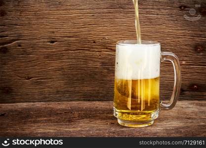 pouring beer in the glass on a wooden floor