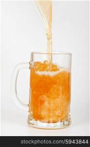 pouring beer into the glass . beer is pouring into glass on white background