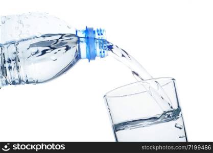 Pouring clean water from a plastic bottle into the glass. Clean water isolated on white. Drinking water concept.
