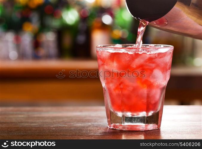 pouring cocktail into a glass