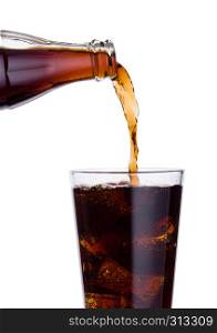 Pouring cola soda drink from bottle to glass with ice cubes on white background
