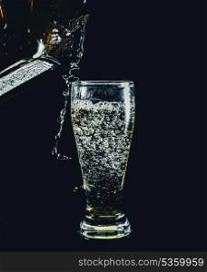 pouring drink in shot glass on black