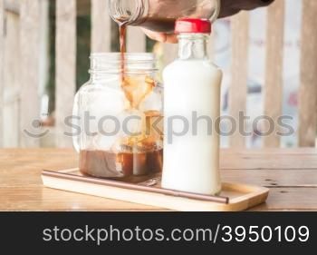 Pouring espresso to iced glass of coffee, stock photo