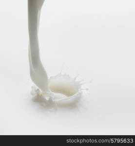 Pouring milk splash on white background macro. Pouring milk splash