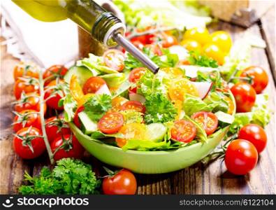 pouring oil into bowl of salad with vegetables