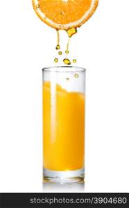 Pouring orange juice from orange into the glass isolated on white