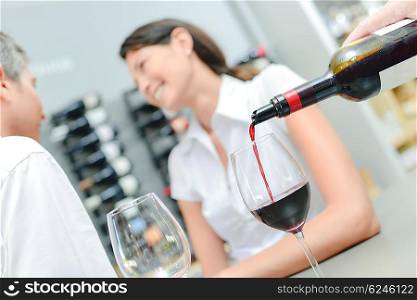 Pouring red wine for couple on a date
