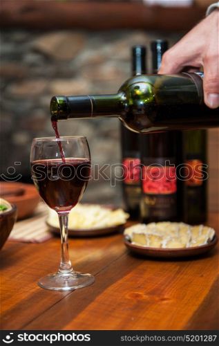 Pouring red wine. Pouring red wine from the bottle to the wineglass