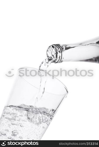 Pouring sparkling mineral water from bottle to glass on white background