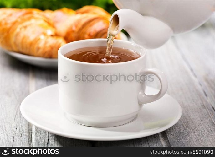 Pouring tea into cup of tea