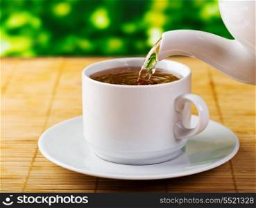 pouring tea into cup of tea